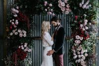 14 a sophisticated Halloween wedding arch decorated with greenery, light pink and deep red blooms is a chic idea for a wedding