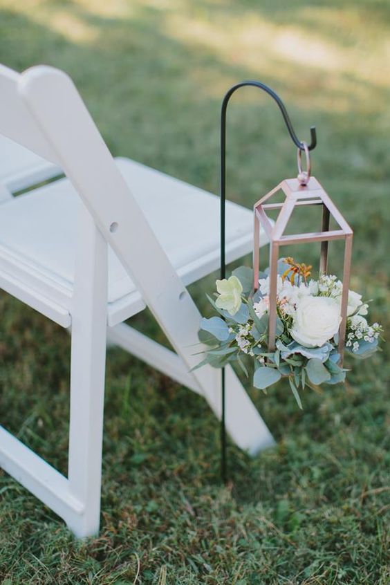 a wedding aisle decorated with a copper hanging lantern with blooms and greenery is an amazing idea for a wedding