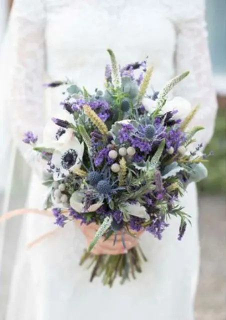 a fantastic textural wedding bouquet with wihte and bold purple blooms, berries, greenery, astilbe and thistles is wow