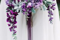 19 a jaw-dropping cascading purple wedding bouquet with purple blooms, air plants, leaves and long ribbon for a fall bride