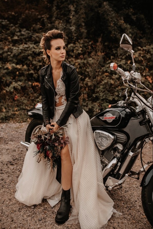 a rock n roll bridal look with a delicate lace top, a printed maxi skirt, black chunky boots, a black leather jacket and a cool rock hairstyle