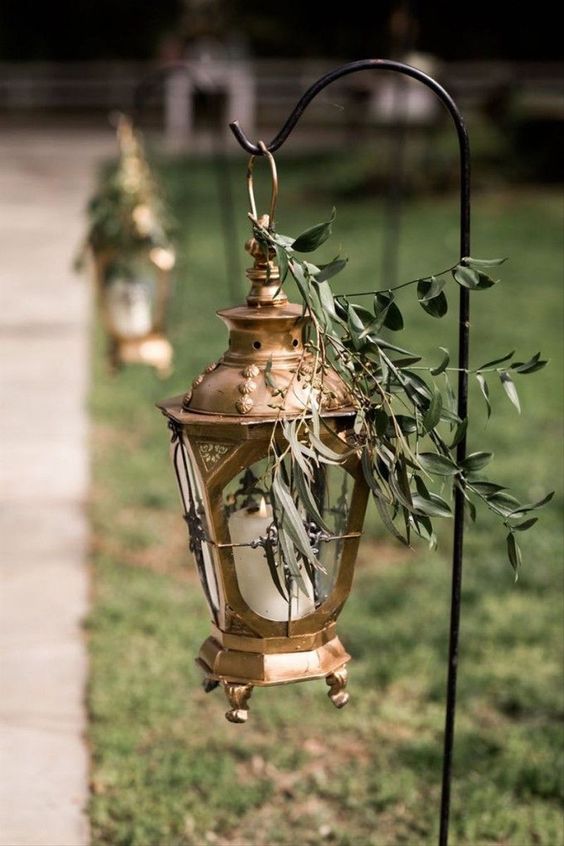gorgeous wedding aisle decor with a beautiful vintage copper candle lantern topped with greenery is amazing