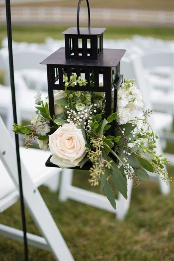 wedding aisle decor with a vintage lantern with neutral blooms and greenery is a lovely idea for a rustic wedding