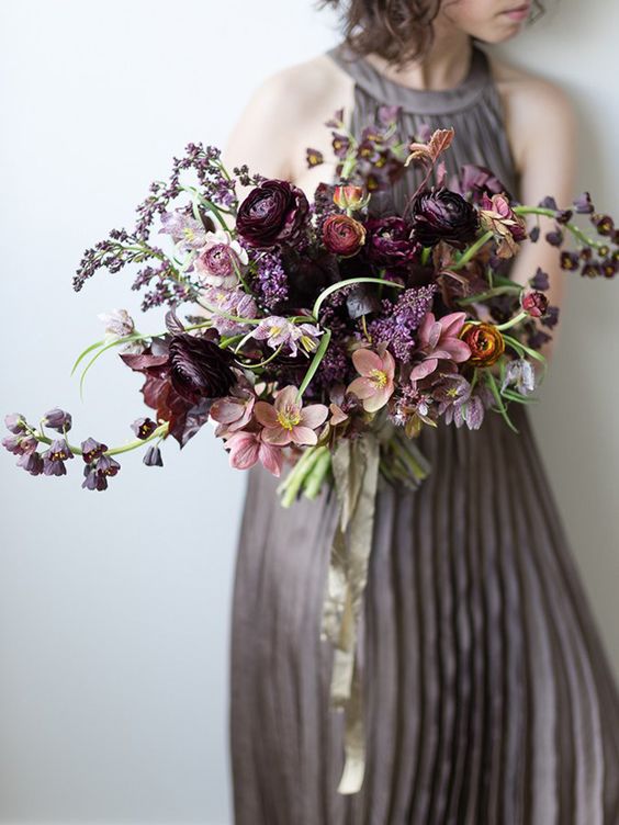 a refined moody wedding bouquet with deep purple, pink, mauve blooms and a bit of greenery for a fall bride