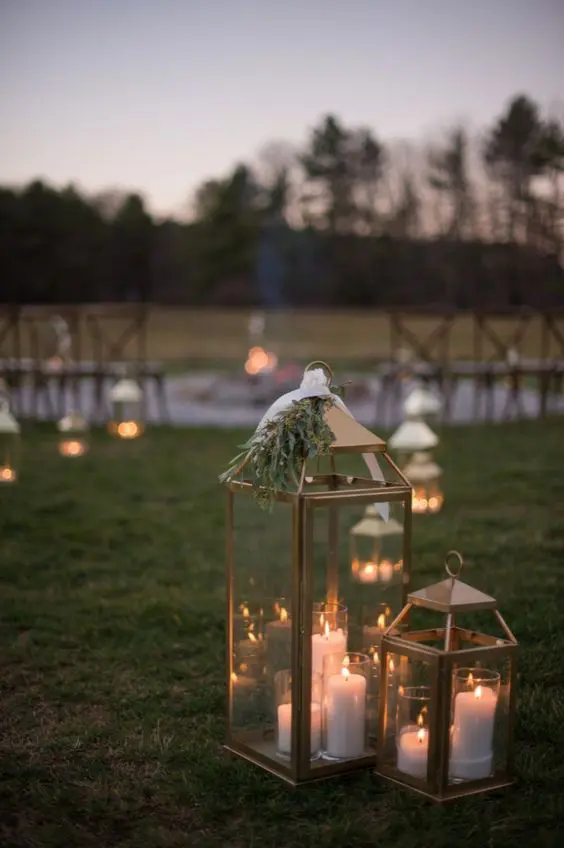 wedding aisle decor with metal candle lanterns topped with greenery is a lovely idea for any wedding