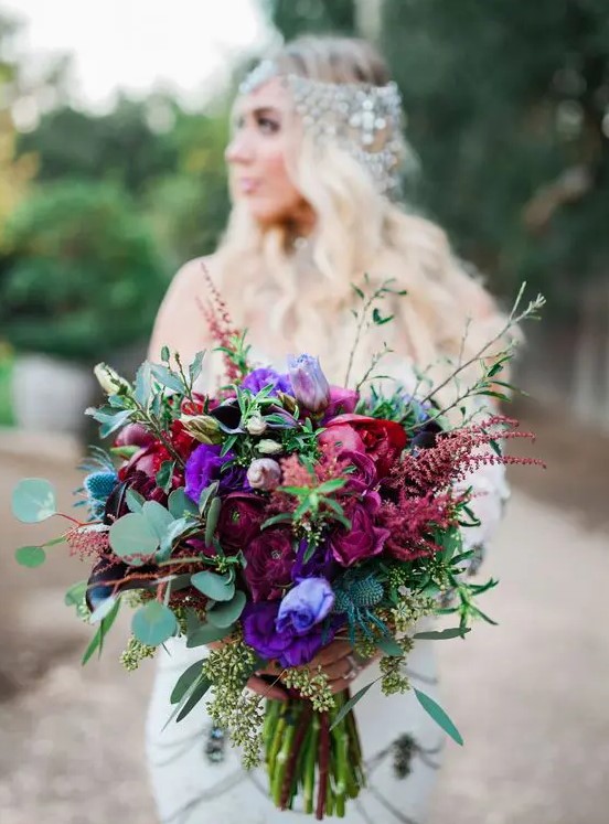 a statement jewel tone wedding bouquet with deep purple, burgundy, violet blooms, thistles and greenery for a bold wedding