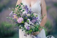 36 a textural and romantic purple wedding bouquet of purple, lilac, pink and neutral blooms, lots of greenery and thistles and long ribbon