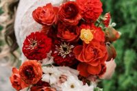 a beautiful and bold wedding bouquet of red roses and dahlias, neutral blooms and fall leaves is a cool color statement for the fall