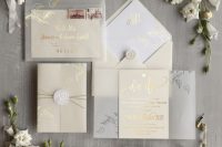 a beautiful neutral champagne and vellum wedding invitation suite with gold foil calligraphy and white seals is wow