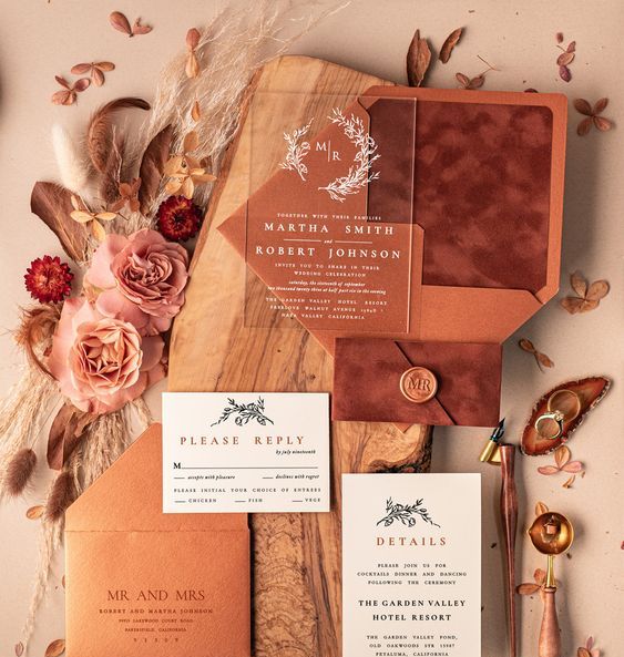 a bold earthy tone wedding invitation suite in orange and rust velvet, with an acrylic part and white invites, with amber seals