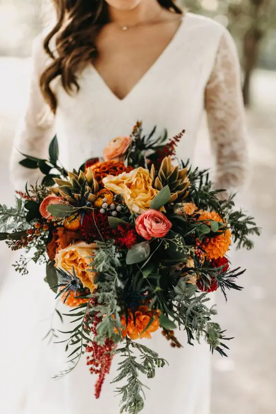 a bold orange wedding bouquet with burgundy and pink blooms, berries, greenery is an amazing idea for the fall