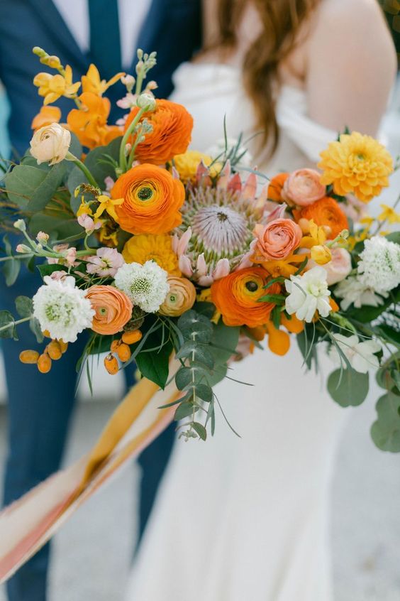 a bright wedding bouquet of orange, yellow, pink and neutral blooms and greenery plus kumquats is a great idea for a summer or fall wedding