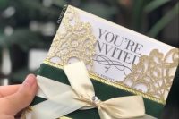 a catchy wedding invitation with black printing, a gold glitter laser cut jacket, a green and a gold ribbon for a fairytale wedding