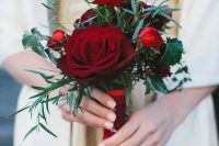 a chic red wedding bouquet of blooms and foliage is all you need for a stylish Christmas wedding
