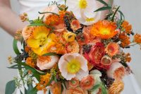a colorful wedding bouquet of orange, yellow and blush blooms and greenery plus privet berries is amazing