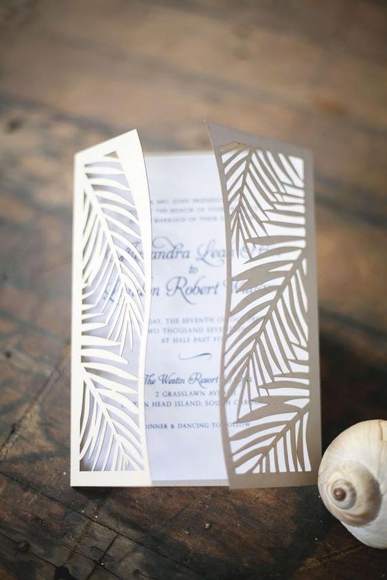 a cool and lovely tropical leaf laser cut wedding invitation with black calligraphy is a lovely idea for a tropical wedding