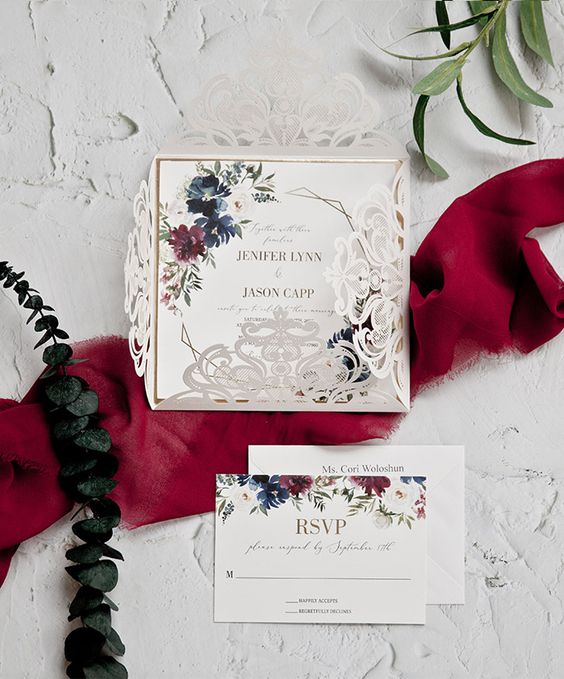 a cool wedding invitation suite with a neutral floral laser cut jacket and bold floral print invitations fro a bold wedding