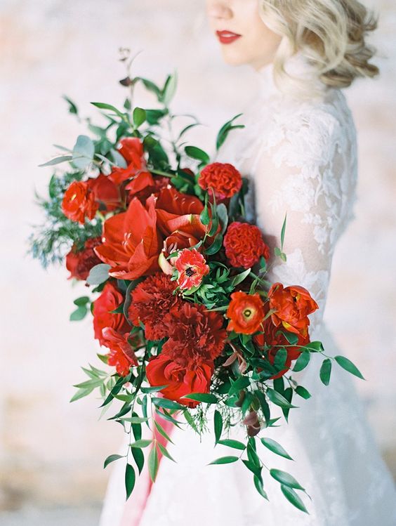 a fab red wedding bouquet of various types of blooms and greenery is a fantastic color statement for your bridal look