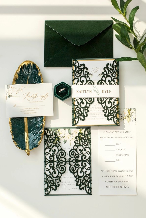 a fantastic wedding invitation suite with a green velvet envelope, green laser cut jackets and gold calligraphy is amazing