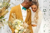 a gorgeous groom’s look with a yellow tuxedo, an emerald bow tie and a white shirt for a summer or boho wedding