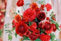 a gorgeous red wedding bouquet of roses and ranunculus and greenery plus some berries is a lovely idea for a fall wedding