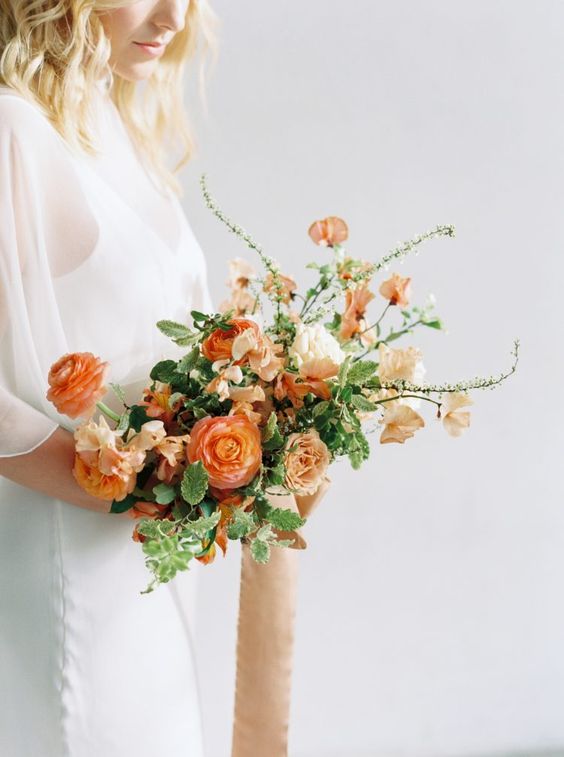 a lovely orange wedding bouquet with blush blooms, twigs and greenery is a cool idea for spring, summer or fall