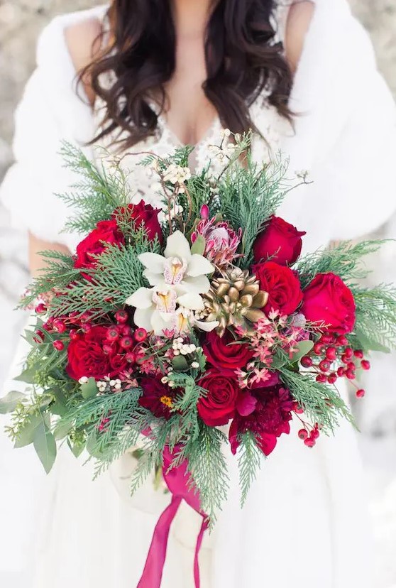 a lush Crhsitmas wedding bouquet with holly berries, bold blooms, orchids, succulents and evergreens