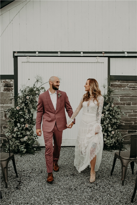 a mauve pantsuit, a white shirt, brown shoes and a delicate floral boutonniere are a nice combo for a summer or fall wedding