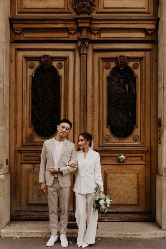 a minimalist groom's look with a tan pantsuit, a white t-shirt and white sneakers is a lovely idea for a neutral wedding