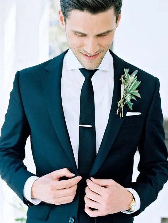 a modern look with a black suit and black tie plus a greenery boutonniere is a win win idea to rock