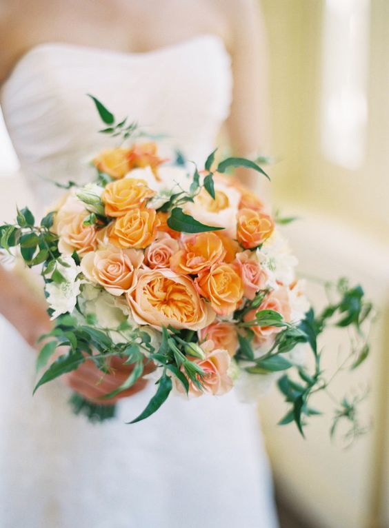 a monochromatic orange wedding bouquet of roses, peony roses and greenery is a lovely idea for a summer or fall wedding