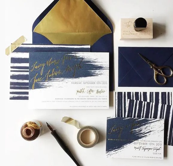 a navy and gold foil wedding staitonery set with brushstrokes and stripes looks unusual and modern