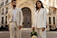 a neutral groom’s look with a creamy pantsuit, a white shirt and white sneakers is a great idea for a neutral wedding