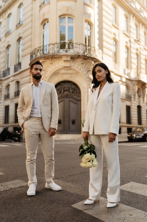 a neutral groom's look with a creamy pantsuit, a white shirt and white sneakers is a great idea for a neutral wedding