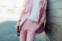 a relaxed and fun modern groom’s look with a pink pantsuit, a fun dragonfly detail on the lapel, a white t-shirt and white sneakers