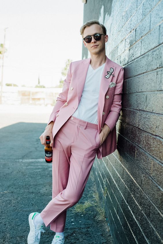 a relaxed and fun modern groom's look with a pink pantsuit, a fun dragonfly detail on the lapel, a white t shirt and white sneakers
