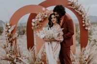 a rust-colored suit, an orange turtleneck, brown shoes for a bold boho desert wedding with a relaxed feel