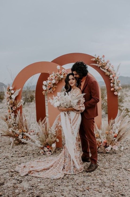 a rust colored suit, an orange turtleneck, brown shoes for a bold boho desert wedding with a relaxed feel