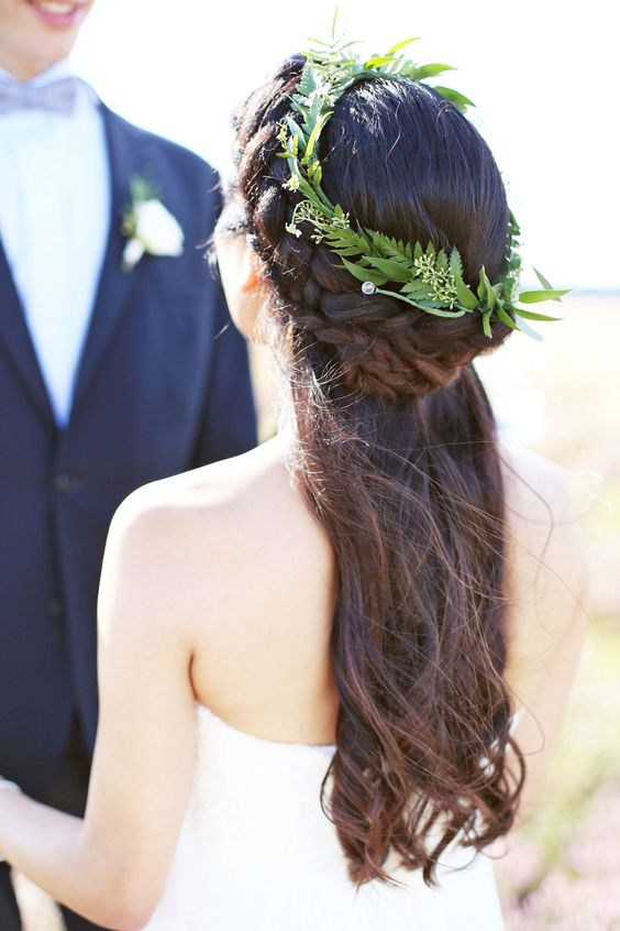 a simple and lovely greenery crown beautifully accents the half updo and little white blooms add interest