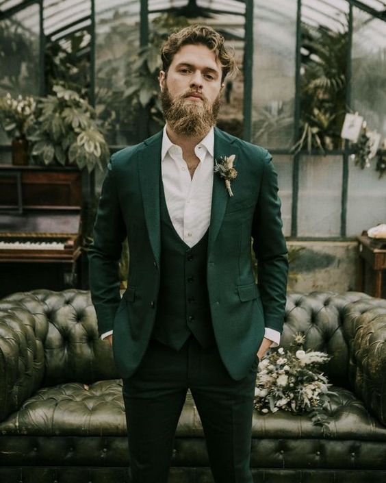 a sophisticated modern groom's look with a green three piece suit, a white shirt and a boutonniere is a lovely idea