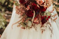 a sophisticated wedding bouquet of deep red dahlias, pink king proteas, greenery and dried flowers is a lovely idea for a fall wedding