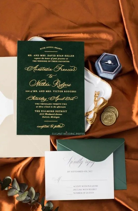 a sophisticated wedding invitation suite with a green envelope and a green velvet invite, gold calligraphy and a neutral envelope