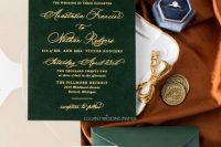 a sophisticated wedding invitation suite with a green envelope and a green velvet invite, gold calligraphu and a neutral envelope