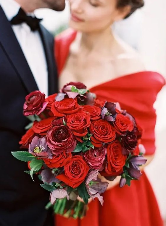 a stunning red and burgundy rose wedding bouquet with leaves is a pretty statement with color to rock at a Valentine wedding