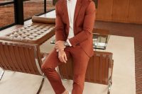 a stylish modern groom’s look with a rust-colored suit, a white shirt and white sneakers is a cool idea for a fall or desert wedding