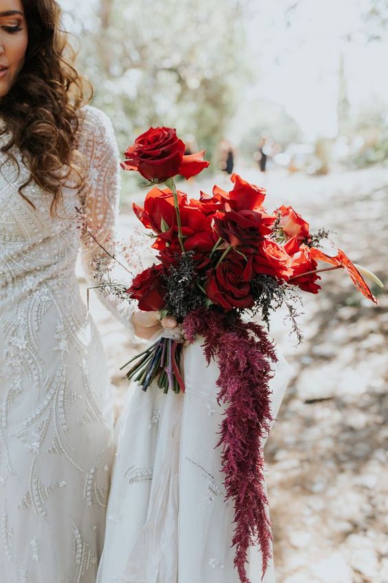 a super chic bold red rose wedding bouquet with lisianthus, greenery and blooming branches is a bold and cool idea to rock