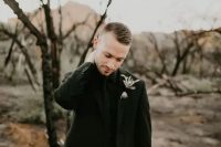 a total black look spruced up only with a dried grass boutonniere is a stylish idea for a modern Halloween groom’s look