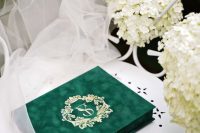 an emerald velvet wedding invitation box with dark green ribbons, gold calligraphy is a lovely idea for a refined wedding