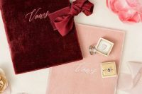 beautiful vow covers in pink and burgundy velvet with calligraphy and ribbon are a very chic and refined idea for a wedding