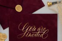 burgundy velvet envelopes with gold calligraphy and gold seals are amazing for a bold fall wedding